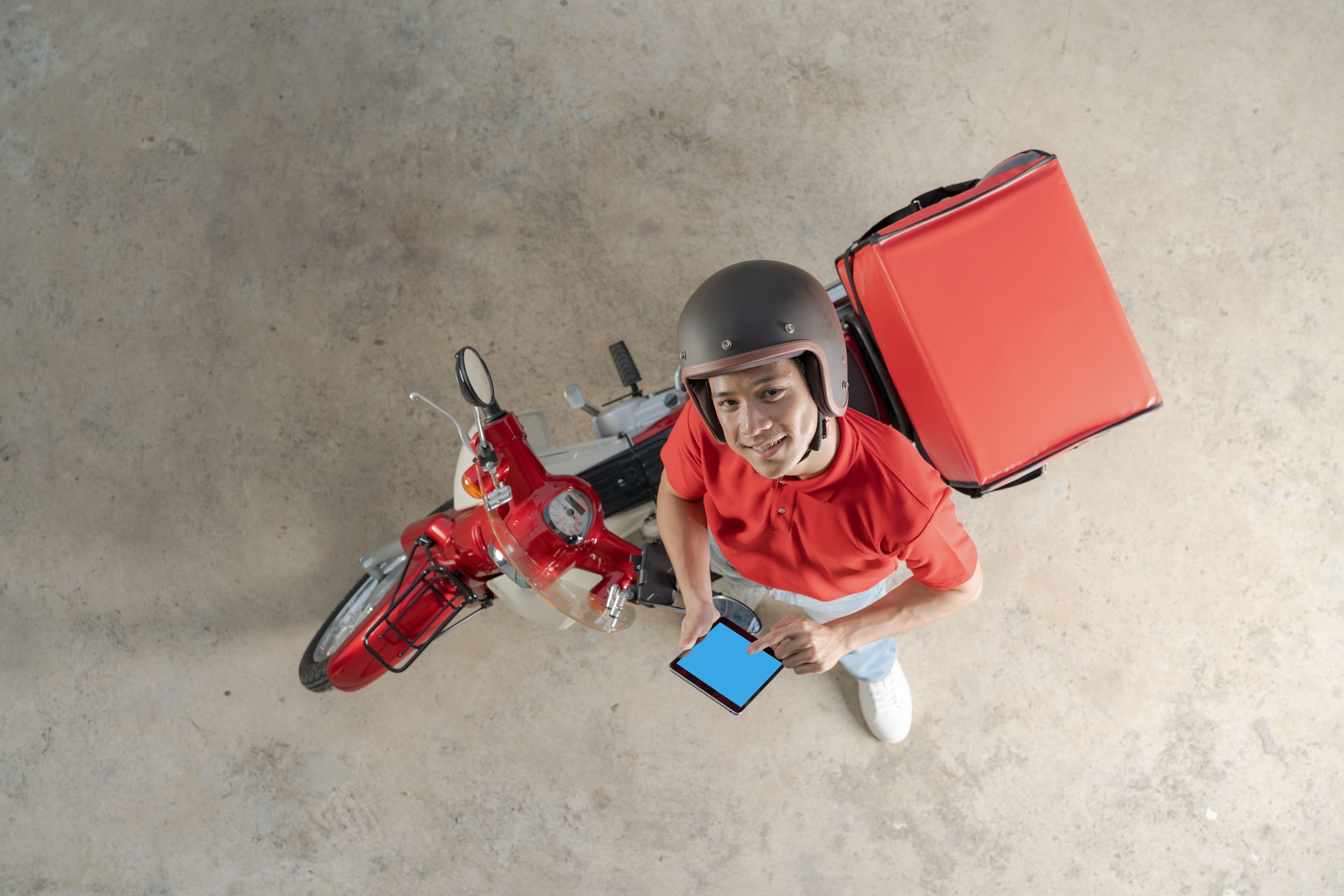 Delivery rider with red motorcycle ready for service